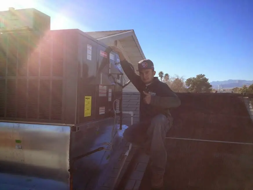 HVAC technician performing AC Tune-Up on a rooftop unit in Sidney